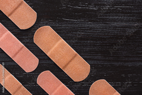 Angled Rows of Adhesive Bandages on Brown Background photo