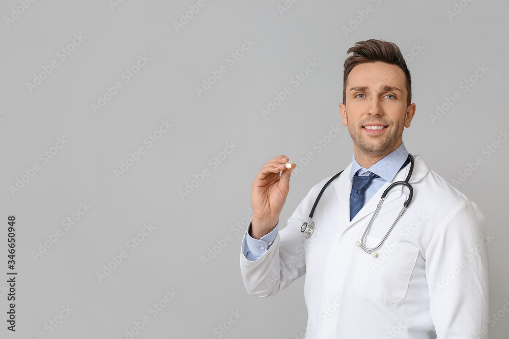Male doctor with flashlight on grey background Male doctor with flashlight on grey background