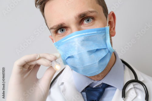 Male doctor with flashlight...