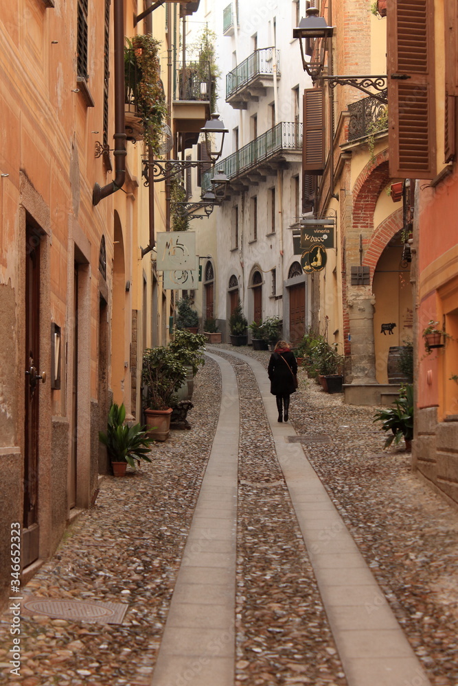 a caucasian woman walks along Acqui Terme citiscape, famous italian spa town