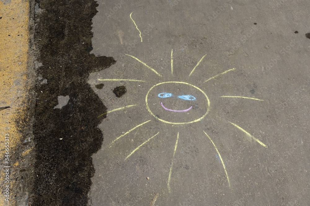 chalk drawing of sun at asphalt