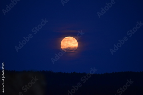 Moon behind clouds in Varmland, Sweden. Very wonderful moon, mysterious.