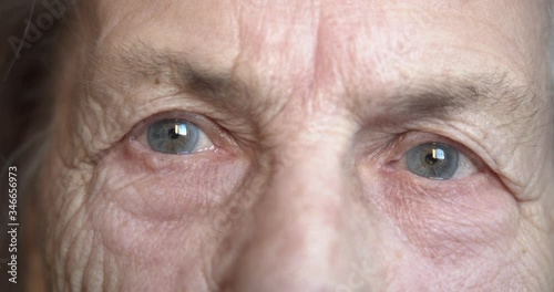 close-up of the eyes of an old elderly woman looking anxiously. lots of wrinkles and wisdom.