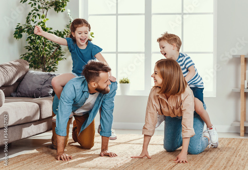 Fotografie Happy parents giving piggyback ride to kids at home.