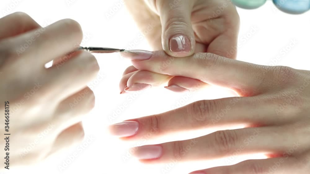 Application of nail polish on nails. Woman applying nude nail polish. manicure process