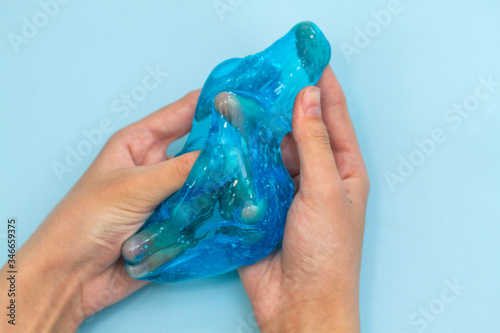 Blue mucus in the hands of a child. Children's creativity, ogre with a liquid consistency, home-made.
 photo