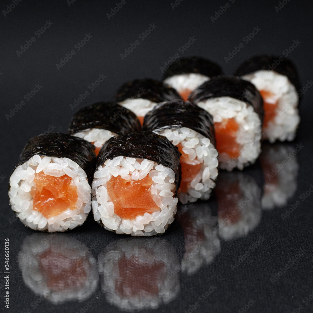 diverse delicious sushi roll set on a black background with reflection, menu