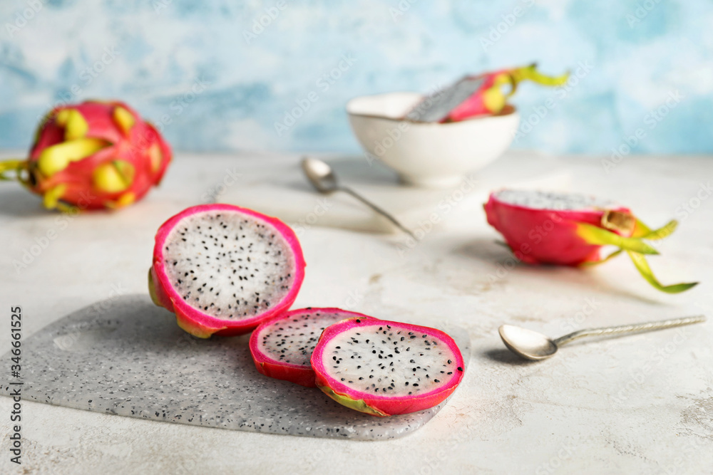 Board with tasty dragon fruit on table