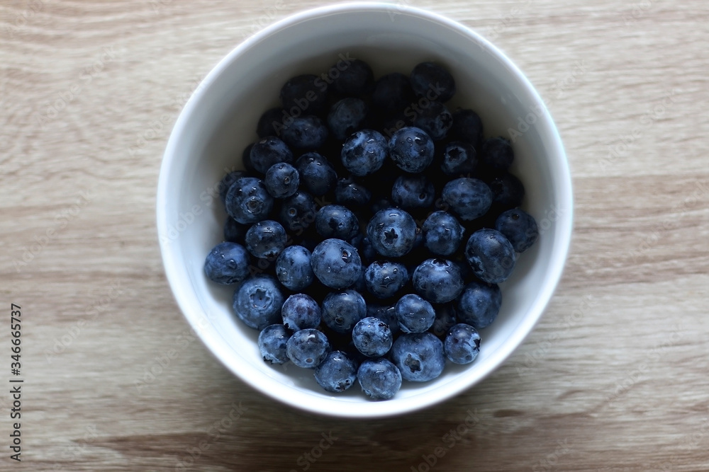 Bowl of fresh blueberries on a table. Top view. Bowl of fresh blueberries on a table. Top view.