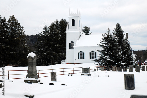 A classic white church is set against white snow photo