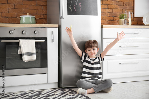 Little boy near refrigerato...