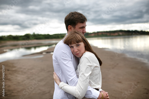 beautiful couple embraces on the beach. The concept of hugs and breakups. Feelings and emotions. Portrait of a woman and a man in close-up.