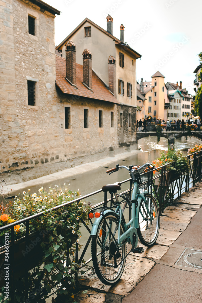 Old bicycle parked near the Palais de l'Ile on the Annecy old town. The Palace, often described as a 