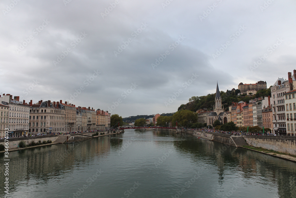 Heading into Vieux Lyon over the Pont Bonaparte. Quai Tilsitt and Quai Fulchiron on the banks of the Saone river, Passerelle, Saint Georges church and Saint-Just College on Fourviere hill, Lyon.