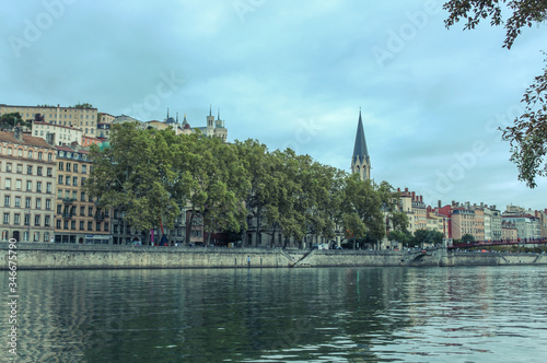 Church of St George with buildings along the Saone River, Quai Fulchiron (quay), in the Old City of Lyon, in the 5th arrondissement (district), Passerelle Saint-Georges bridge, and the Fourviere hill. photo