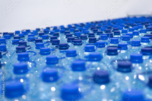 Lot of bottles worth with clean cool natural water. Group of plastic bottles with water stand in a row.