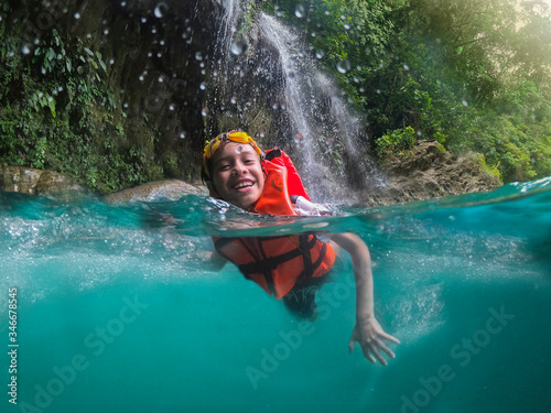 boy swimming in crystal clear waters of the Huasteca Potosina in Mexico. Effect within the water and sky photo