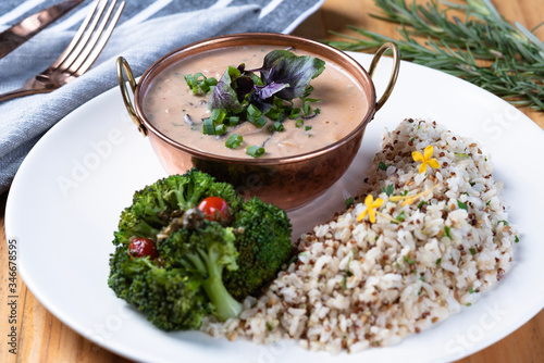 Vegetarian stroganoff with brown rice and brocolis on a rustic wooden table. Vegan food photo