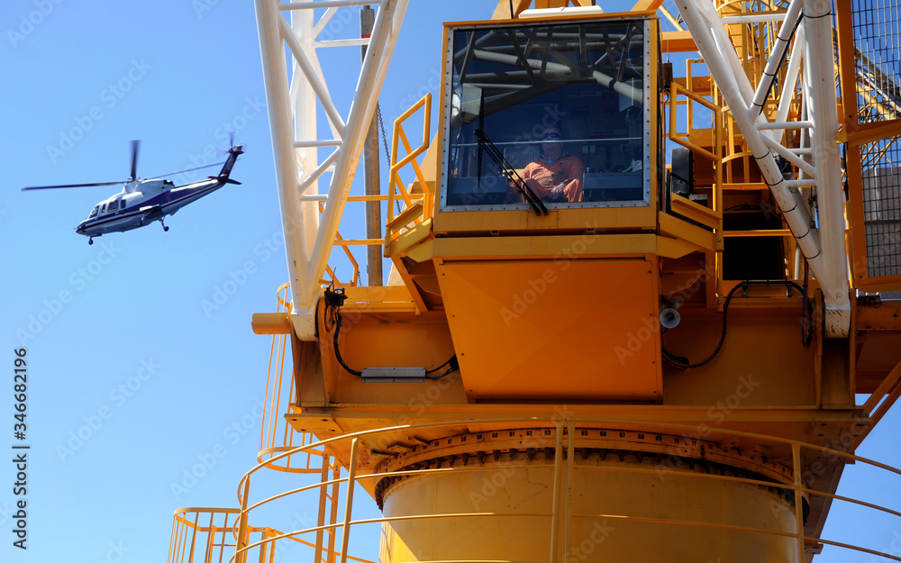 offshore helicopter passes over working crane offshore helicopter passes over working crane