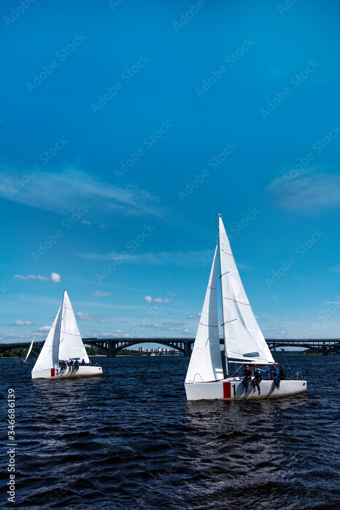 sailboat on the river at sunny day in city