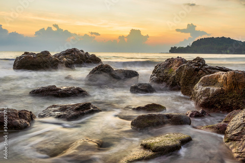 Morning scenery with beautiful skies on the coast with waves lapping against the rocks