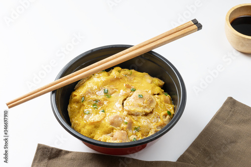 Oyako-don rice bowl topped with chicken, onions and egg cooked with special sauce. oyakodonburi Japanese food on white background. photo