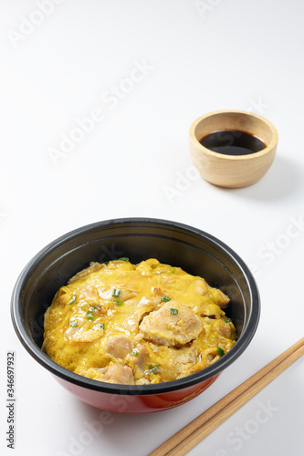 Oyako-don rice bowl topped with chicken, onions and egg cooked with special sauce. oyakodonburi Japanese food on white background.