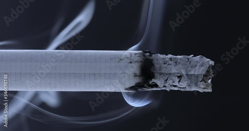 Smoldering cigarette on a black background. Smoke from a cigarette	
