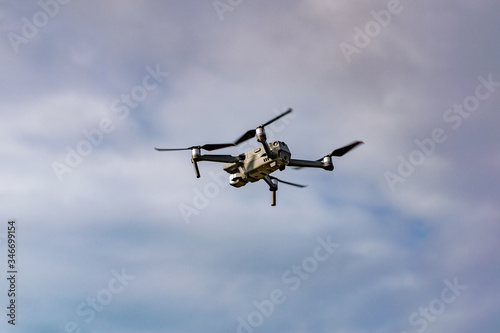 Drone with professional camera flying in the blue sky