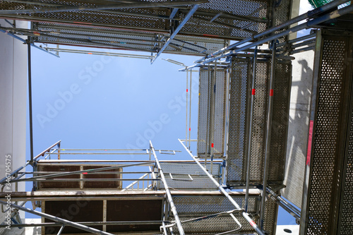 a building shaft is scaffolded on a construction site © karegg
