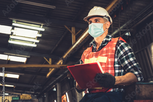 Factory workers with face mask protect from outbreak of Coronavirus Disease 2019 or COVID-19. Concept of protective action and quarantine to stop spreading of Coronavirus Disease 2019 or COVID-19. photo