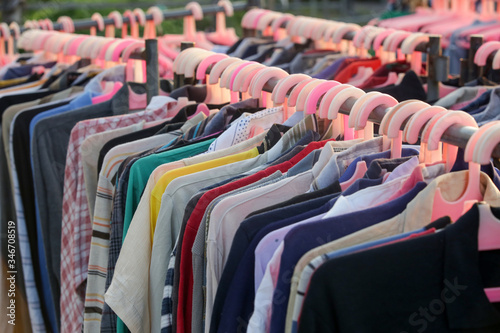 Obraz na plátně Huge selection of different used clothes for men, women and children on the rack in a second hand shop or thrift store