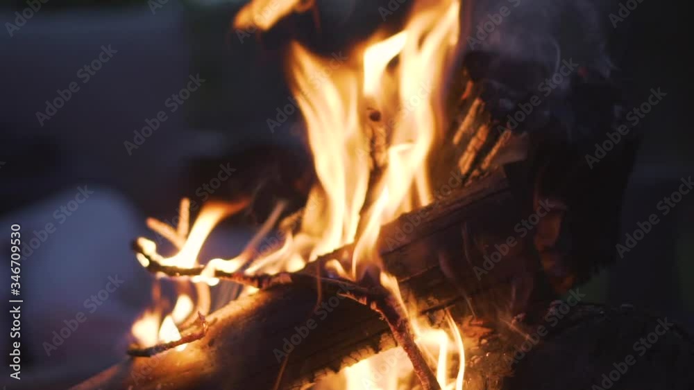 Close up of campfire flames at twilight. Handheld, slomo Close up of campfire flames at twilight. Handheld, slomo