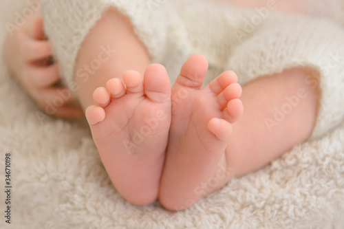 Beautiful little feet of a newborn baby wrapped in cloth. © Kai Grim