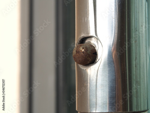 Rusty metal linked of adjustable jointed on stainless bar. Corrosion from weathered concept. 