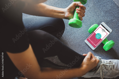 Online shopping and modern lifestyle concept: young woman shopping online while resting after workout in fitness home.