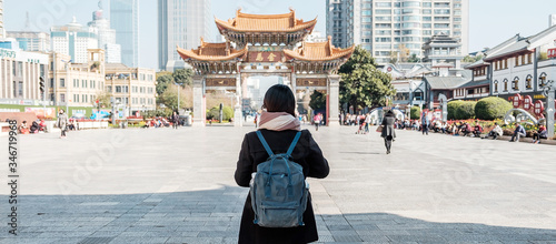 Fotografie, Obraz Young woman traveler traveling at Jinbi square, golden Horse and Jade Rooster Archways