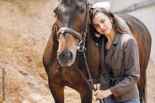 Fototapeta Naklejka Na Ścianę i Meble -  Woman standing with a horse. Lady in a brown jacket