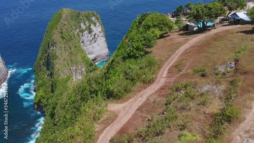 Drone Shot of Indonesia Nusa Penida Kelingking Beach (Manta Bay), aerial view. Camera reveals the beach after it rises in the air. photo