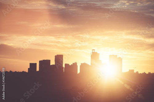Sunrise with flares over Chatswood Australia  with sun rising between buildings.