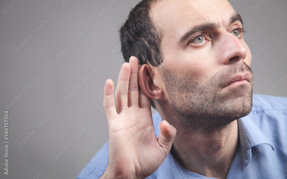 Fototapeta premium Caucasian man hold hand near ear. Trying to hear a gossip