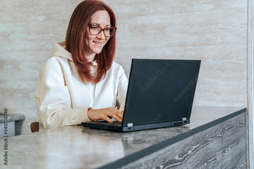 Smiling young woman with laptop. Blogger or student working on computer at home. Work from home, distance education, online learning concept