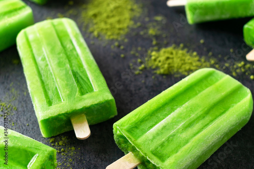 Homemade Matcha tea popsicles ice cream on dark background.