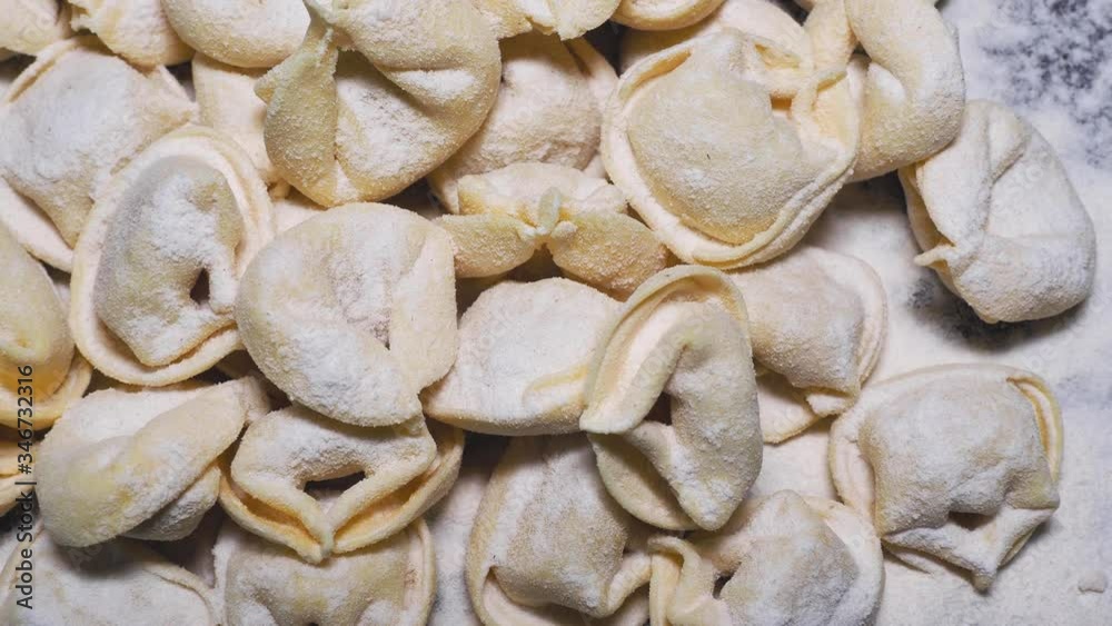 Delicious tortellini a ring-shaped pasta from Italy. Traditionally they are stuffed with a mix of meat, parmigiano reggiano cheese, egg and nutmeg. Black background Delicious tortellini a ring-shaped pasta from Italy. Traditionally they are stuffed with a mix of meat, parmigiano reggiano cheese, egg and nutmeg. Black background