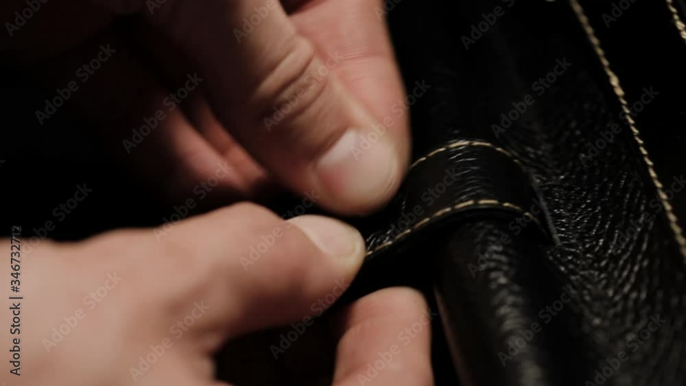 installing the rivet in the leather. The master makes a leather bag closeup. mounting the