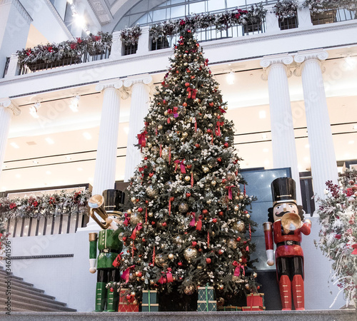 a large beautiful Christmas tree with balls and two huge nutcrackers in a shopping center. New Year.