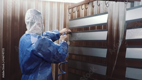 Man cleans detail, preparing for painting. Painting chamber