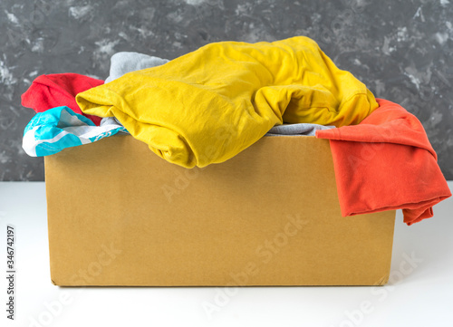 Summer clothes in a cardboard box. Seasonal clothing for shipping or donation. Close up view. photo