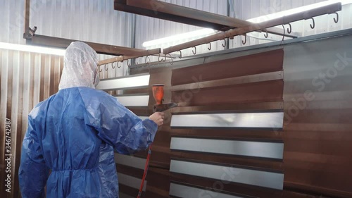 A man is painting the metal parts