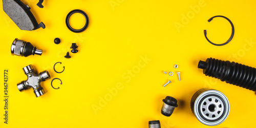 Set of car parts for maintenance on yellow background